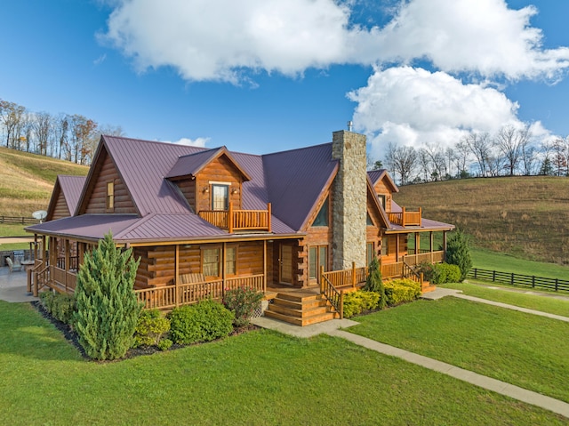 log home featuring a rural view, a balcony, and a front lawn