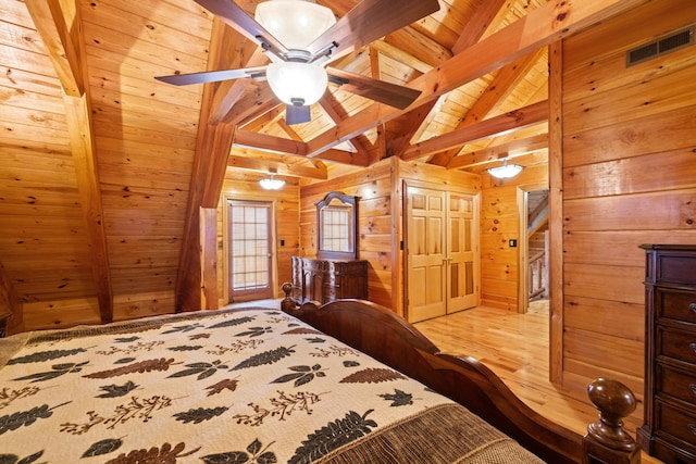 bedroom with ceiling fan, wooden ceiling, vaulted ceiling with beams, light hardwood / wood-style flooring, and wooden walls