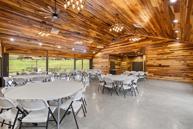 dining room with ceiling fan, wood walls, concrete flooring, and wood ceiling