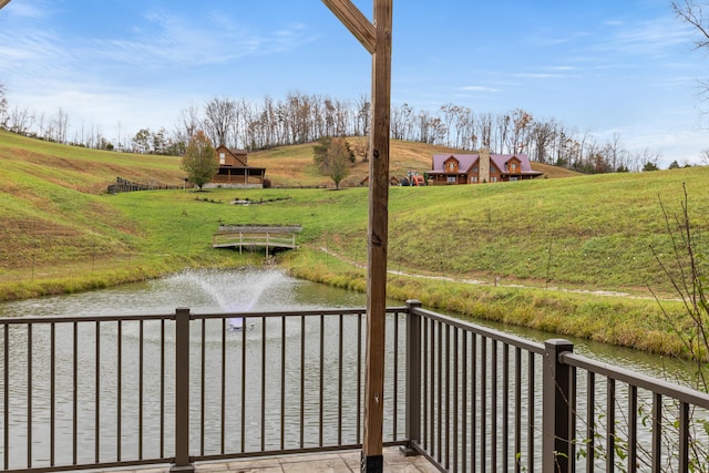 exterior space with a lawn, a water view, and a rural view