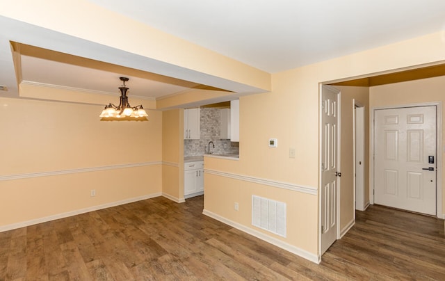 empty room with dark hardwood / wood-style flooring and crown molding