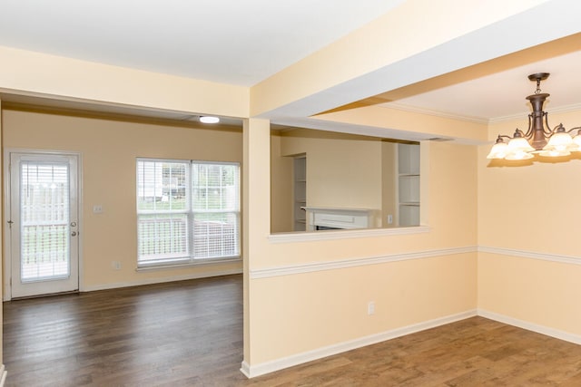 unfurnished room with crown molding, wood-type flooring, and a notable chandelier