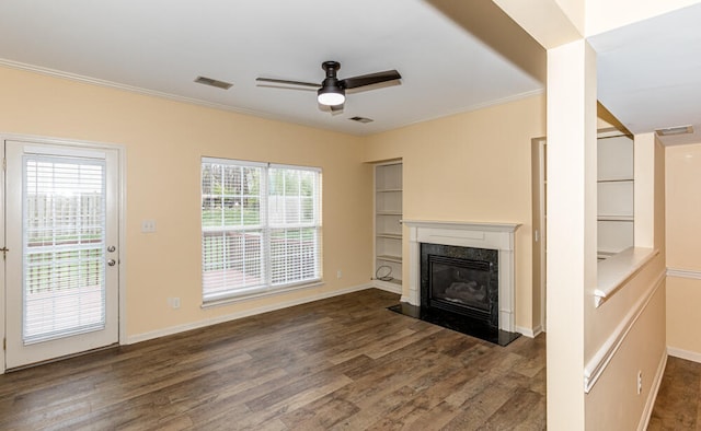 unfurnished living room with dark hardwood / wood-style floors, plenty of natural light, and a premium fireplace