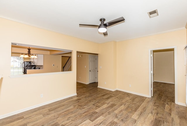 unfurnished living room featuring ceiling fan with notable chandelier, light wood-type flooring, and crown molding