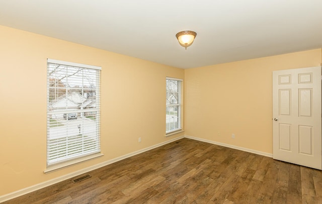 unfurnished room featuring plenty of natural light and hardwood / wood-style floors