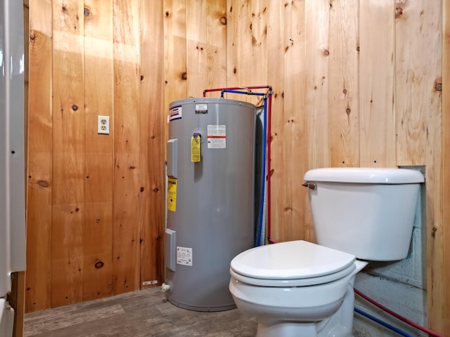 bathroom with wood walls, toilet, wood-type flooring, and water heater