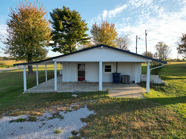 rear view of property featuring a lawn and central AC