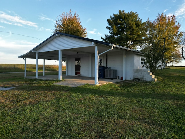 back of property with a yard and central AC unit