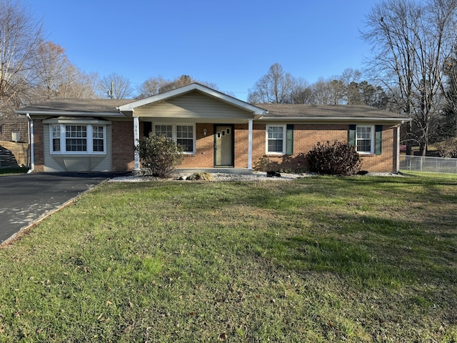 ranch-style home featuring a porch and a front lawn