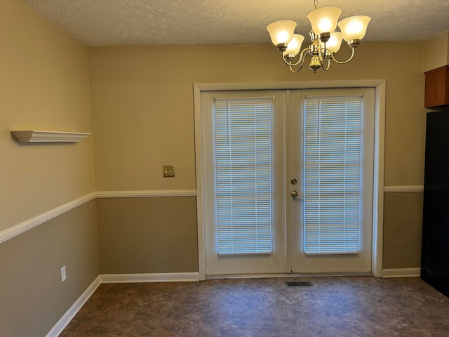 doorway with french doors, a notable chandelier, and dark colored carpet