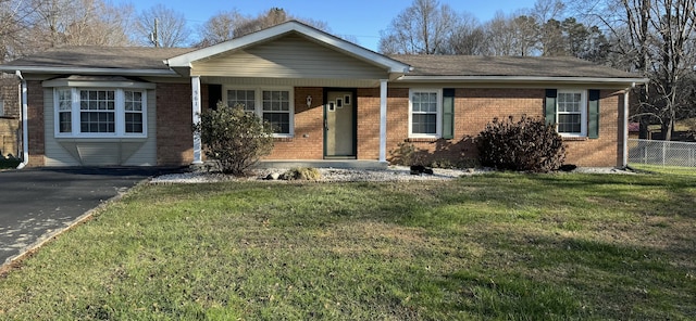 ranch-style home featuring covered porch and a front yard