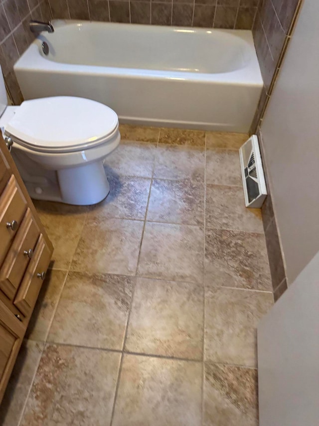 bathroom featuring toilet and a tub to relax in