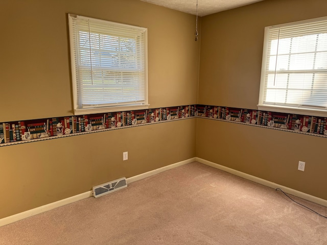 carpeted spare room featuring a textured ceiling