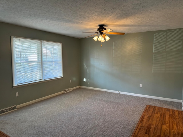 spare room with carpet, ceiling fan, and a textured ceiling