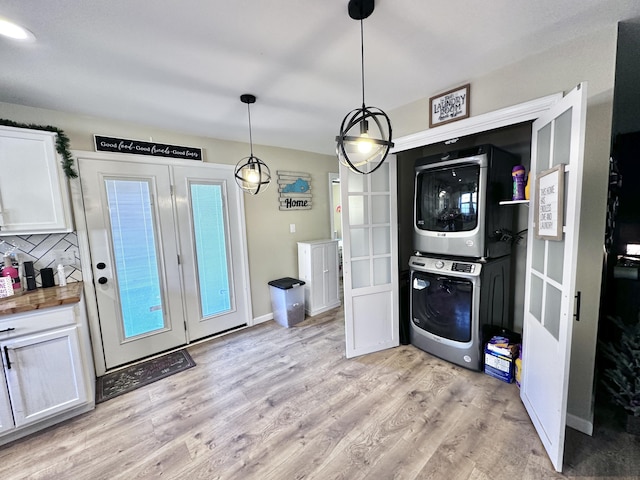 laundry area featuring stacked washer and dryer and light hardwood / wood-style floors