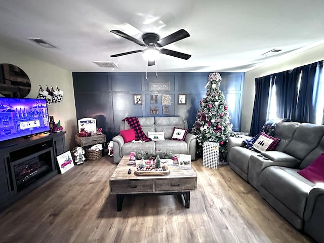 living room with ceiling fan and wood-type flooring