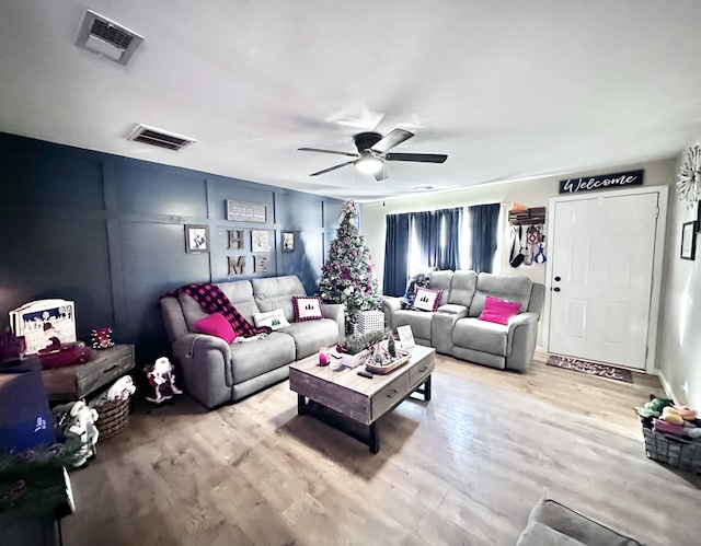 living room with ceiling fan and light hardwood / wood-style flooring