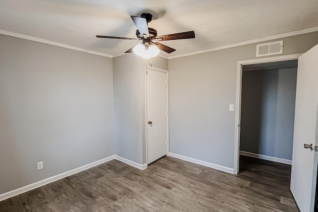 unfurnished bedroom featuring a closet, crown molding, ceiling fan, and dark wood-type flooring