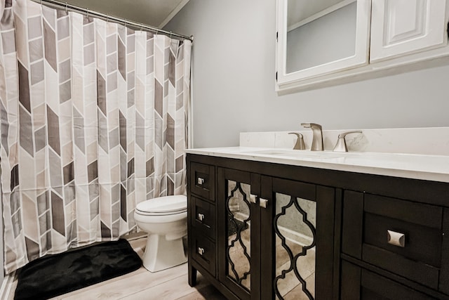 bathroom with vanity, toilet, and ornamental molding