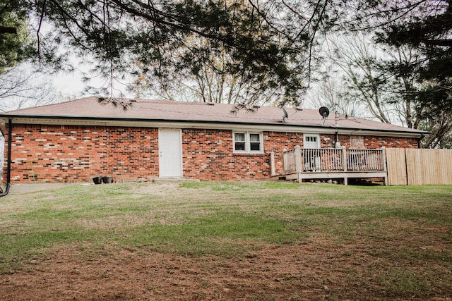 back of property featuring a lawn and a deck