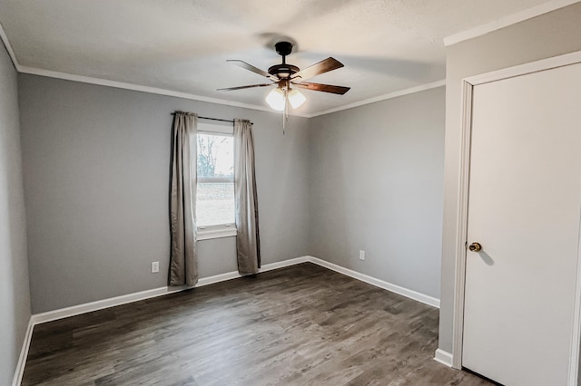 spare room with dark hardwood / wood-style flooring, ceiling fan, and crown molding