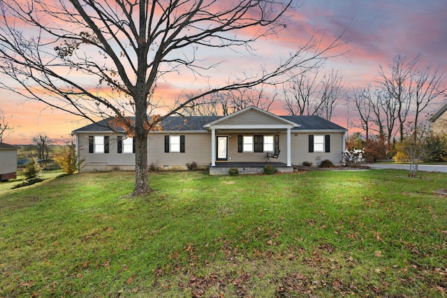 ranch-style home featuring a yard and covered porch