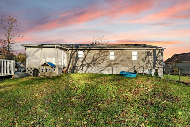 yard at dusk featuring a sunroom