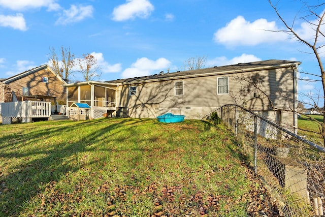 rear view of house with a lawn and a sunroom