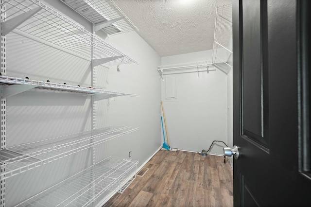 clothes washing area featuring hardwood / wood-style floors and a textured ceiling