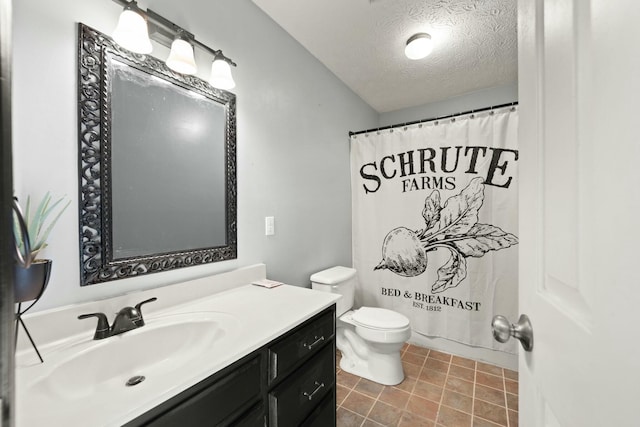 bathroom with vanity, toilet, and a textured ceiling