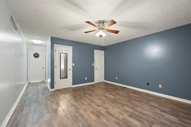 empty room featuring ceiling fan, dark hardwood / wood-style flooring, and a textured ceiling