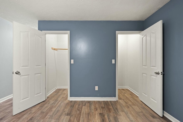 unfurnished bedroom featuring a textured ceiling and dark hardwood / wood-style floors