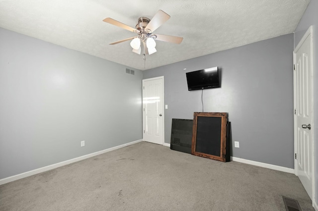 interior space featuring light carpet, a textured ceiling, and ceiling fan