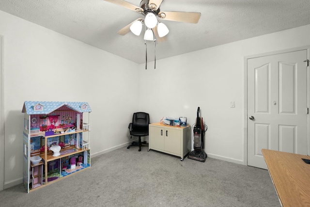 office area with light carpet, ceiling fan, and a textured ceiling