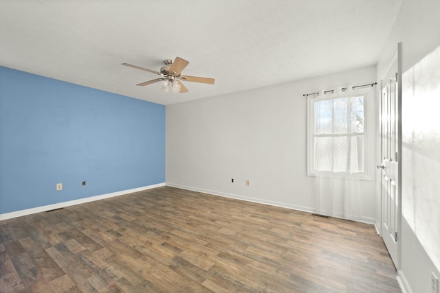 spare room with ceiling fan and dark hardwood / wood-style flooring