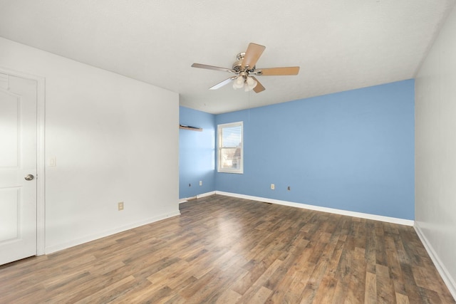 empty room featuring ceiling fan and dark wood-type flooring