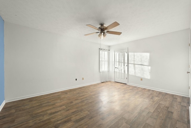 empty room with a textured ceiling, dark hardwood / wood-style floors, and ceiling fan