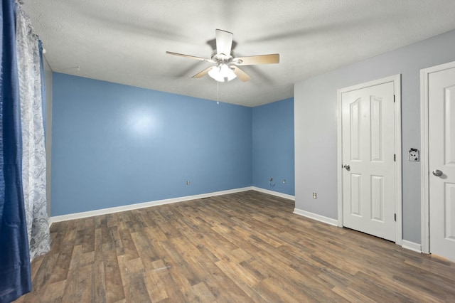 unfurnished bedroom with a textured ceiling, dark hardwood / wood-style floors, and ceiling fan