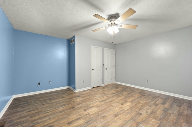 unfurnished bedroom featuring ceiling fan, dark hardwood / wood-style flooring, and a textured ceiling