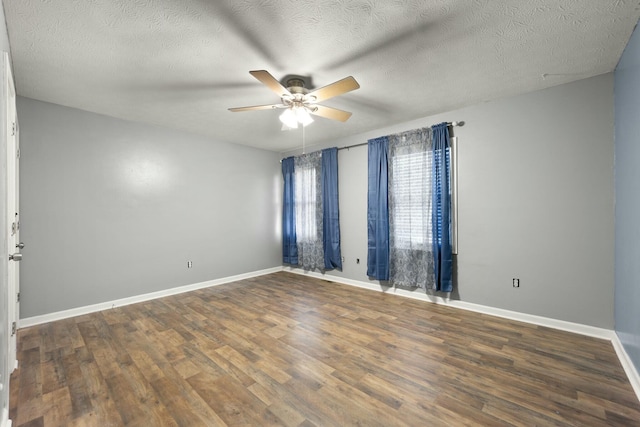 empty room with a textured ceiling, ceiling fan, and dark wood-type flooring