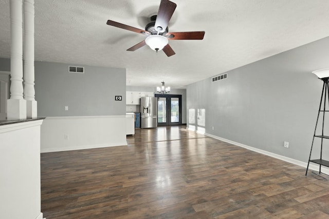 unfurnished living room featuring french doors, dark hardwood / wood-style flooring, a textured ceiling, and ceiling fan with notable chandelier