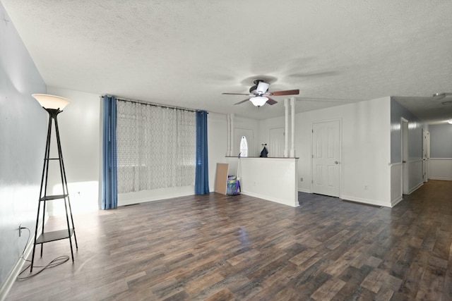 unfurnished living room with a textured ceiling, dark hardwood / wood-style flooring, and ceiling fan