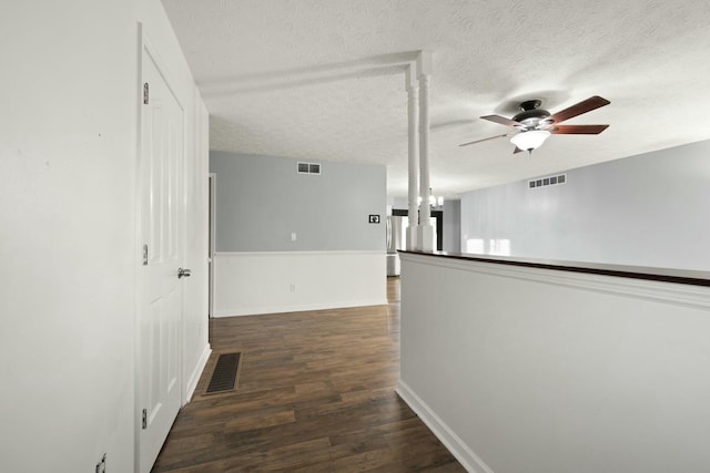 hallway featuring dark hardwood / wood-style flooring, a textured ceiling, and a chandelier