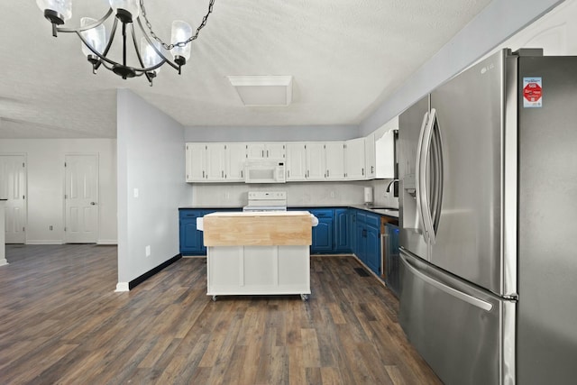 kitchen with white appliances, white cabinets, blue cabinets, sink, and a chandelier