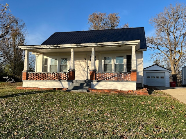 view of front of home with a porch, an outbuilding, a front yard, and a garage