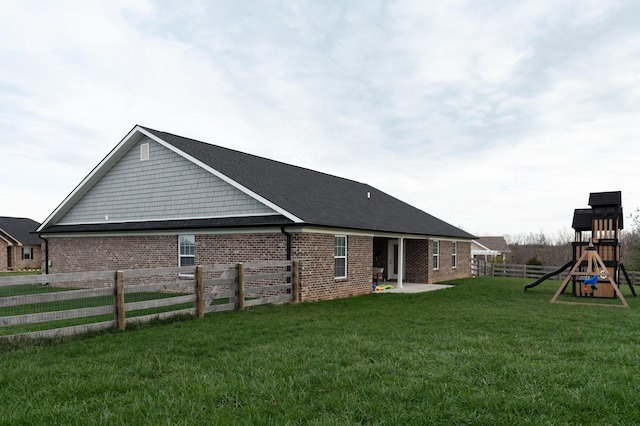 view of side of home featuring a playground, a yard, and a patio