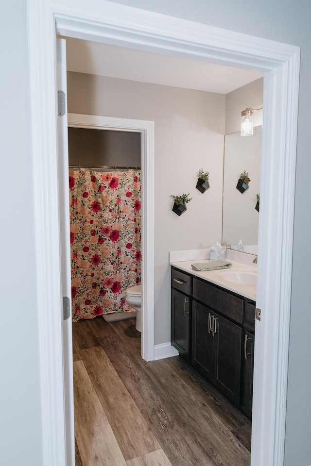 bathroom featuring hardwood / wood-style floors, vanity, and toilet