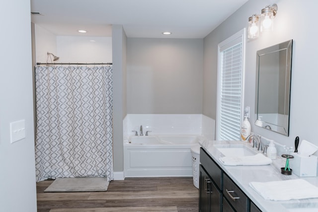 bathroom with hardwood / wood-style flooring, vanity, and shower with separate bathtub