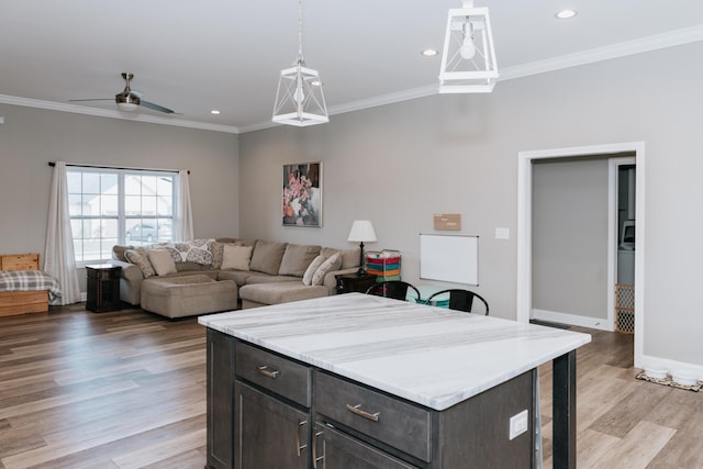 kitchen featuring ceiling fan, dark brown cabinets, and light wood-type flooring