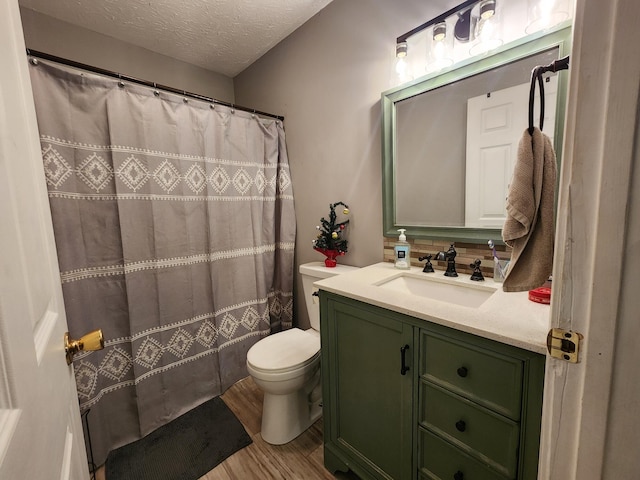 bathroom featuring hardwood / wood-style floors, vanity, toilet, a textured ceiling, and curtained shower